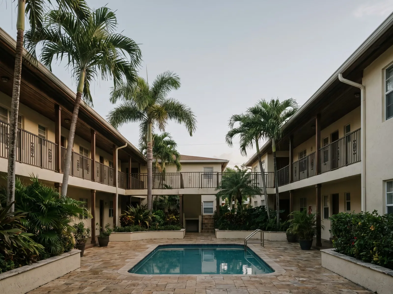 A garden-style apartment complex with palm trees and balconies in Hollywood, Florida.