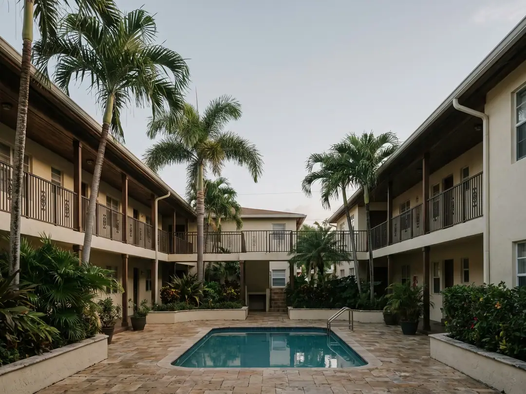 A garden-style apartment complex with palm trees and balconies in Hollywood, Florida.
