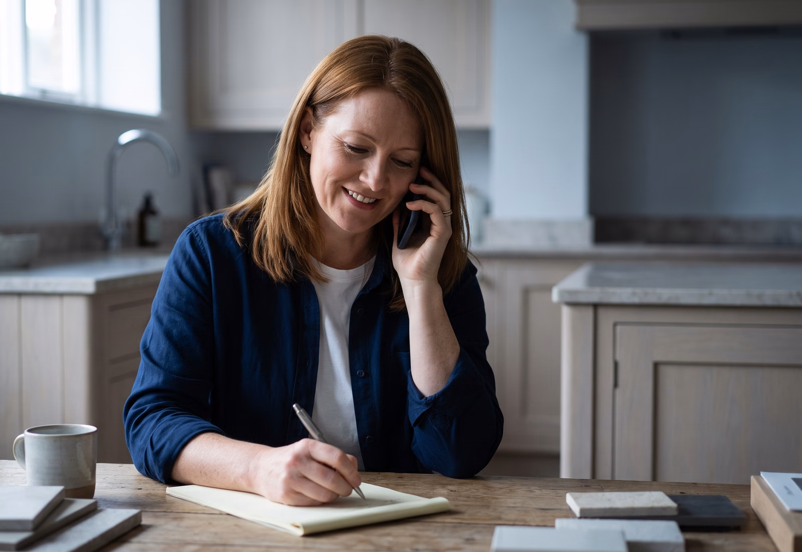 The owner taking a new customer call at her desk